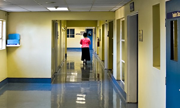 A woman walking down a corridor in a hospital