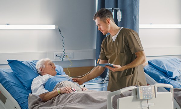 Photo of nursing associate with patient, illustrating story about nursing associate adverts