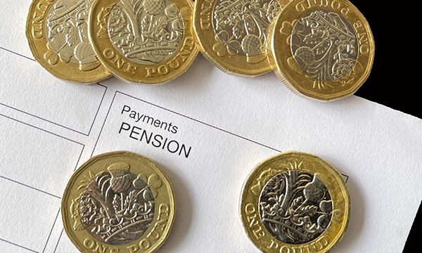 Some £1 coins spread on a document with the word pension printed under the heading payments